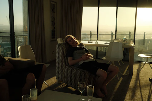 A sleek massage chair in a bright, modern apartment overlooking a bustling cityscape at sunset.