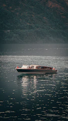 Electric boat gliding over calm waters of Kupiškio marios surrounded by nature.