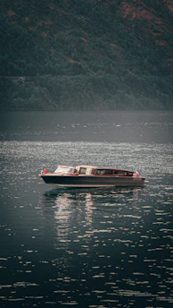 Electric boat gliding over calm waters of Kupiškio marios surrounded by nature.