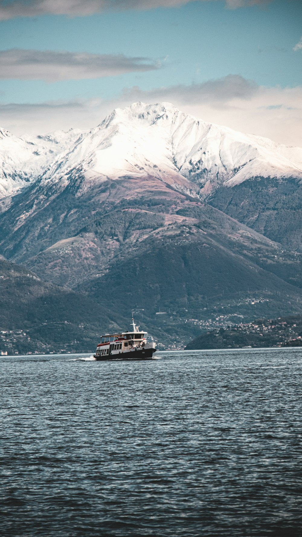 a boat on a large body of water with mountains in the background
