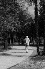 a black and white photo of a man walking down a path