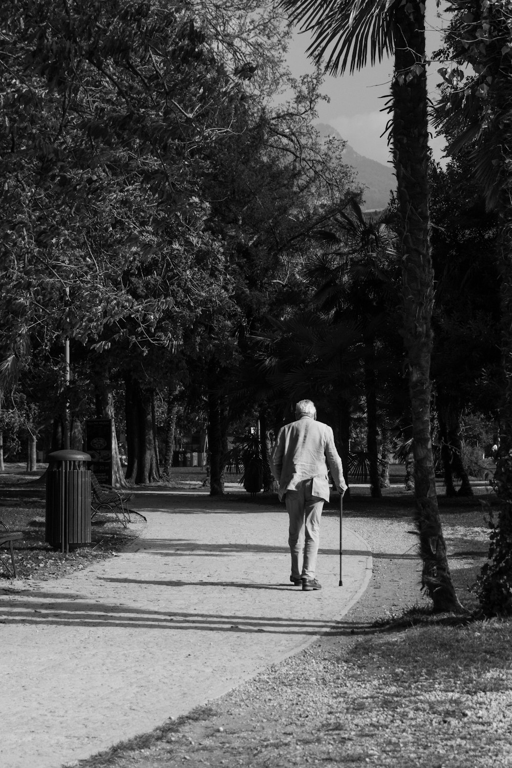 a black and white photo of a man walking down a path