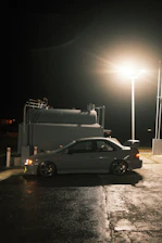 A sleek fuel delivery vehicle parked on a city street at dusk with soft lighting.