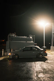 A sleek fuel delivery vehicle parked on a city street at dusk with soft lighting.