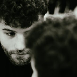 a man with curly hair looking at his cell phone