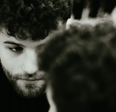 a man with curly hair looking at his cell phone