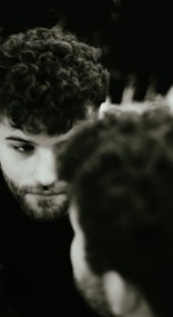 Acting class participant with curly hair checking his cell phone