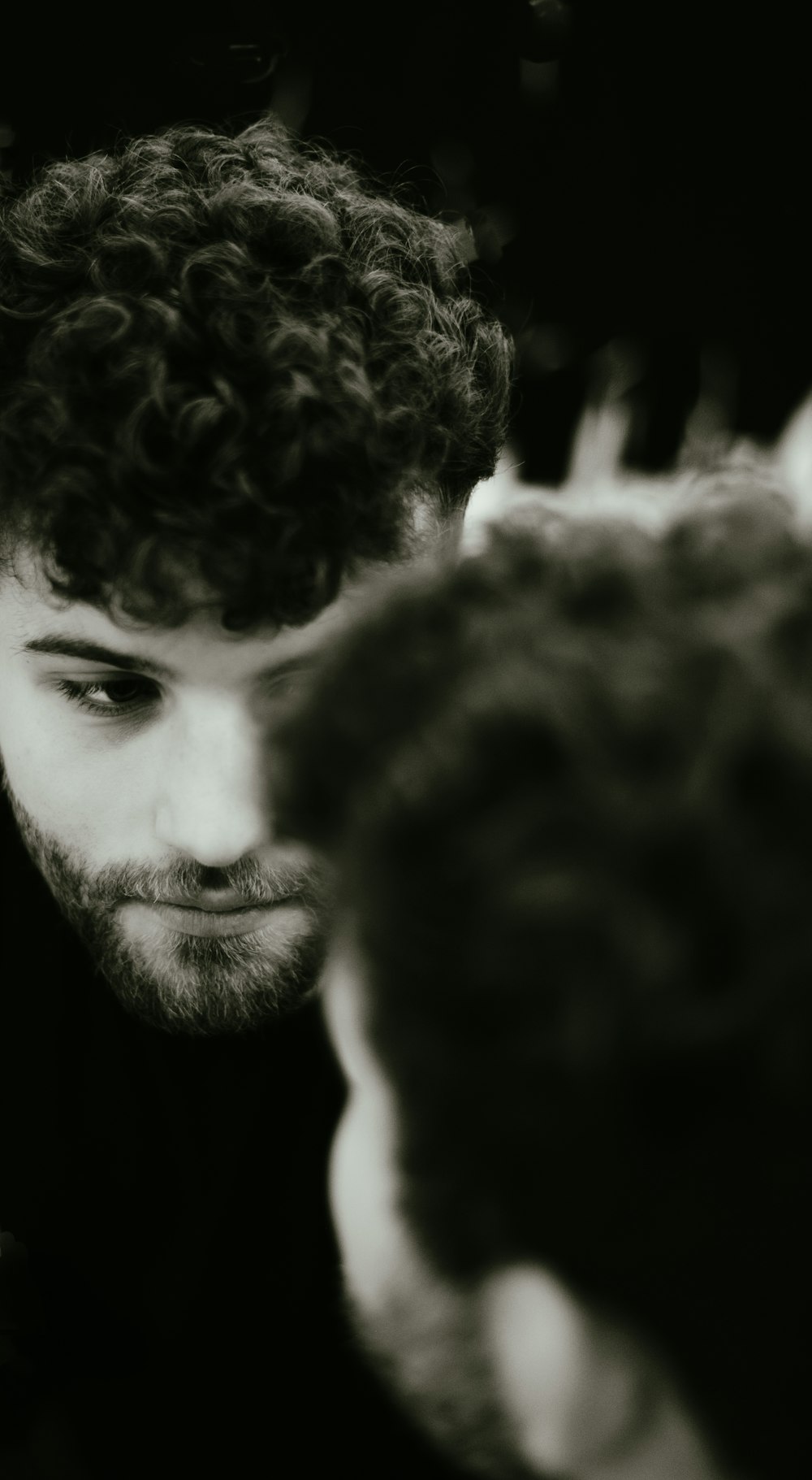 a man with curly hair looking at his cell phone