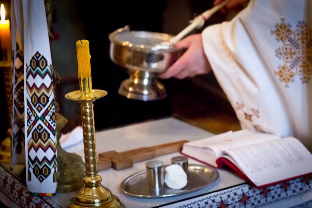 a priest is lighting a candle in a church