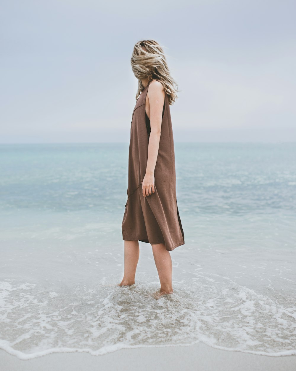 eine frau, die im wasser am strand steht