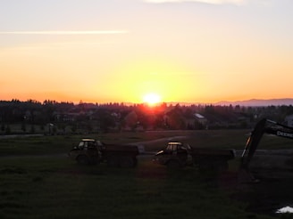 A sunset view of a water truck in operation at a landscaping project.