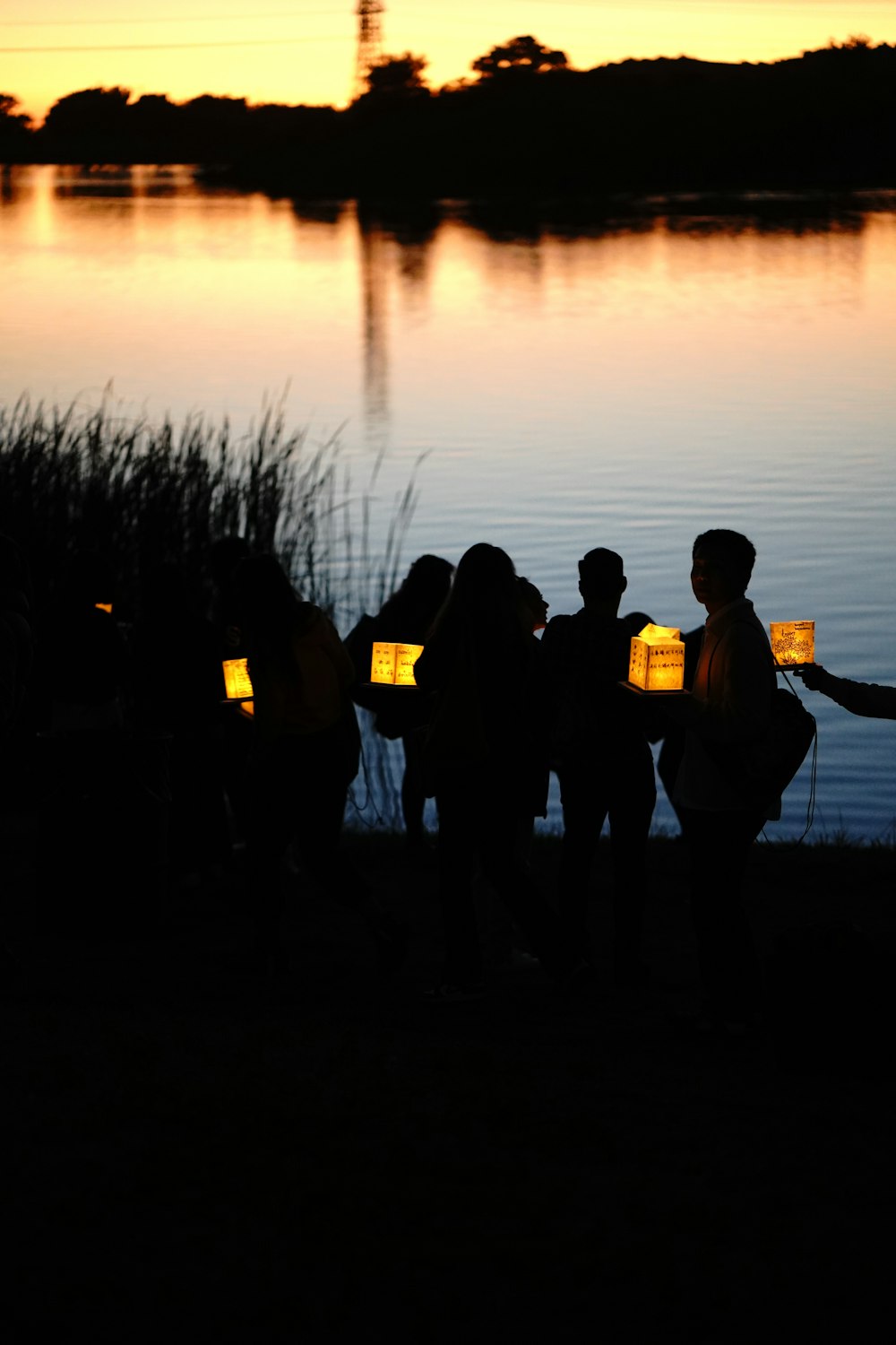 a group of people standing next to a body of water