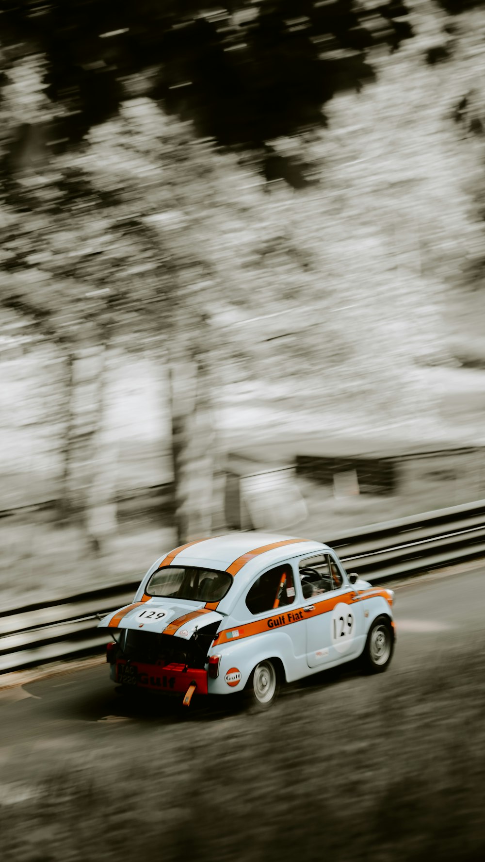 a white and orange car driving down a road
