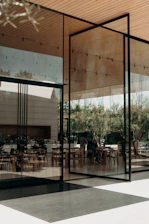 a restaurant with glass walls and tables and chairs