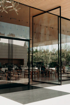 a restaurant with glass walls and tables and chairs