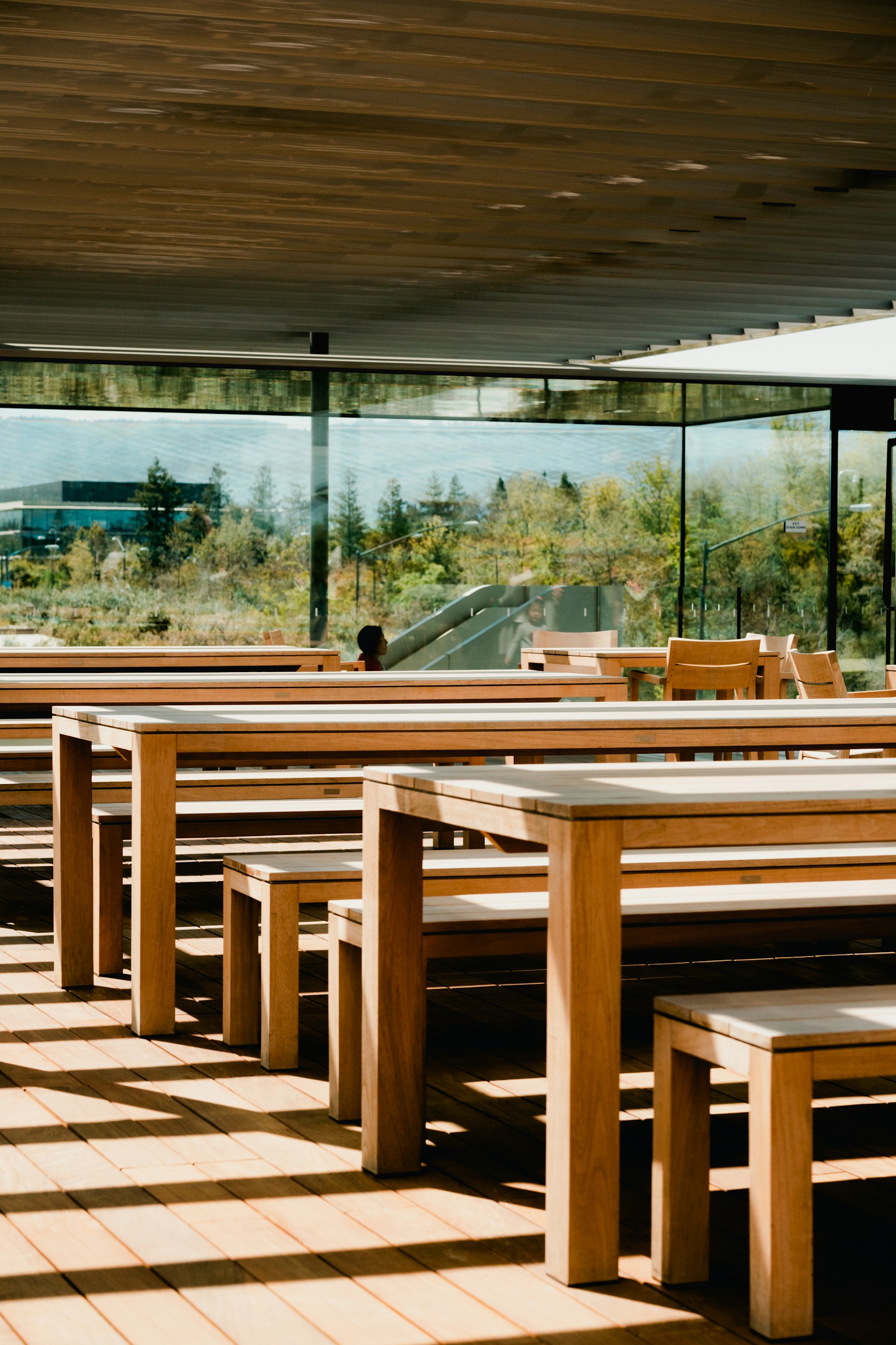 a row of wooden benches sitting under a roof