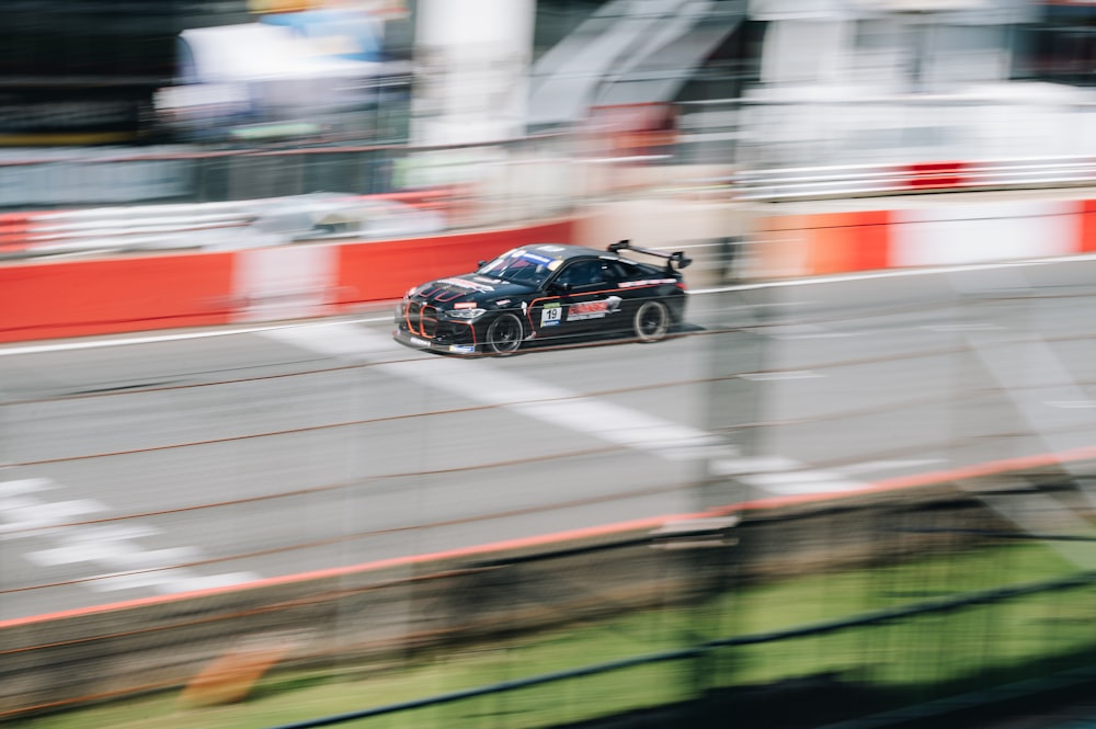 a car driving down a race track with a blurry background