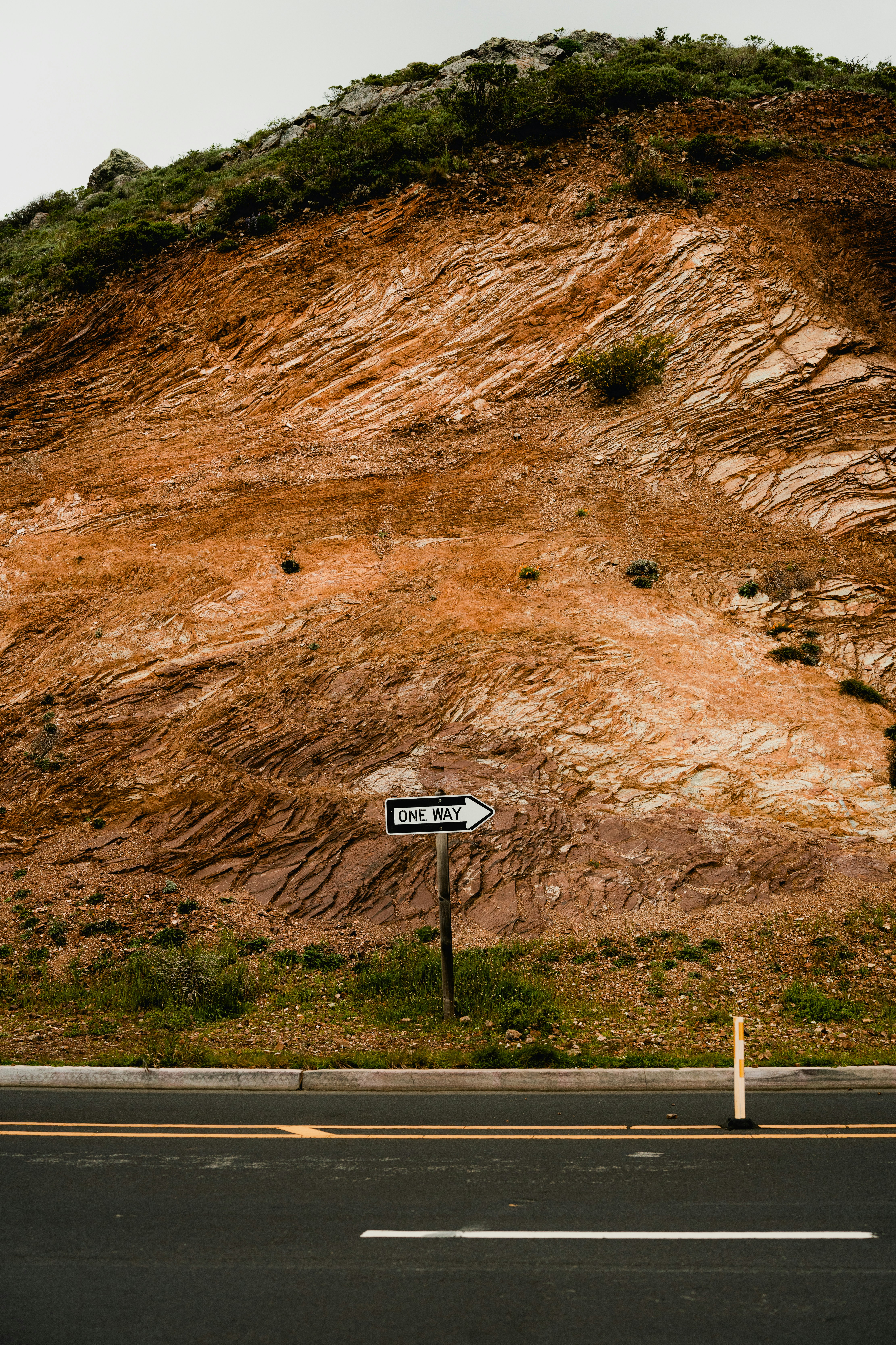ein Straßenschild, das am Straßenrand sitzt