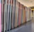A neatly arranged row of colorful books or folders is lined up on a dark surface, with each cover adding a different hue to the sequence. The angle of the photo captures the long stretch of the arrangement, providing a sense of order and organization.