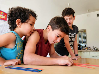 Kids gathered around a table building simple science projects with enthusiasm.