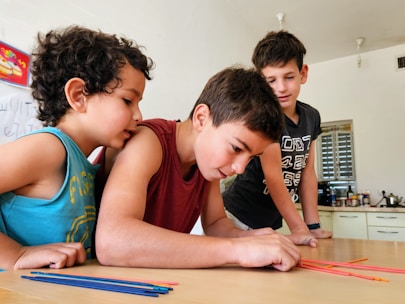 A teacher guiding a small group of children through a colorful logic puzzle activity.