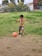 A happy child wearing a colorful soccer jersey while playing in a park.