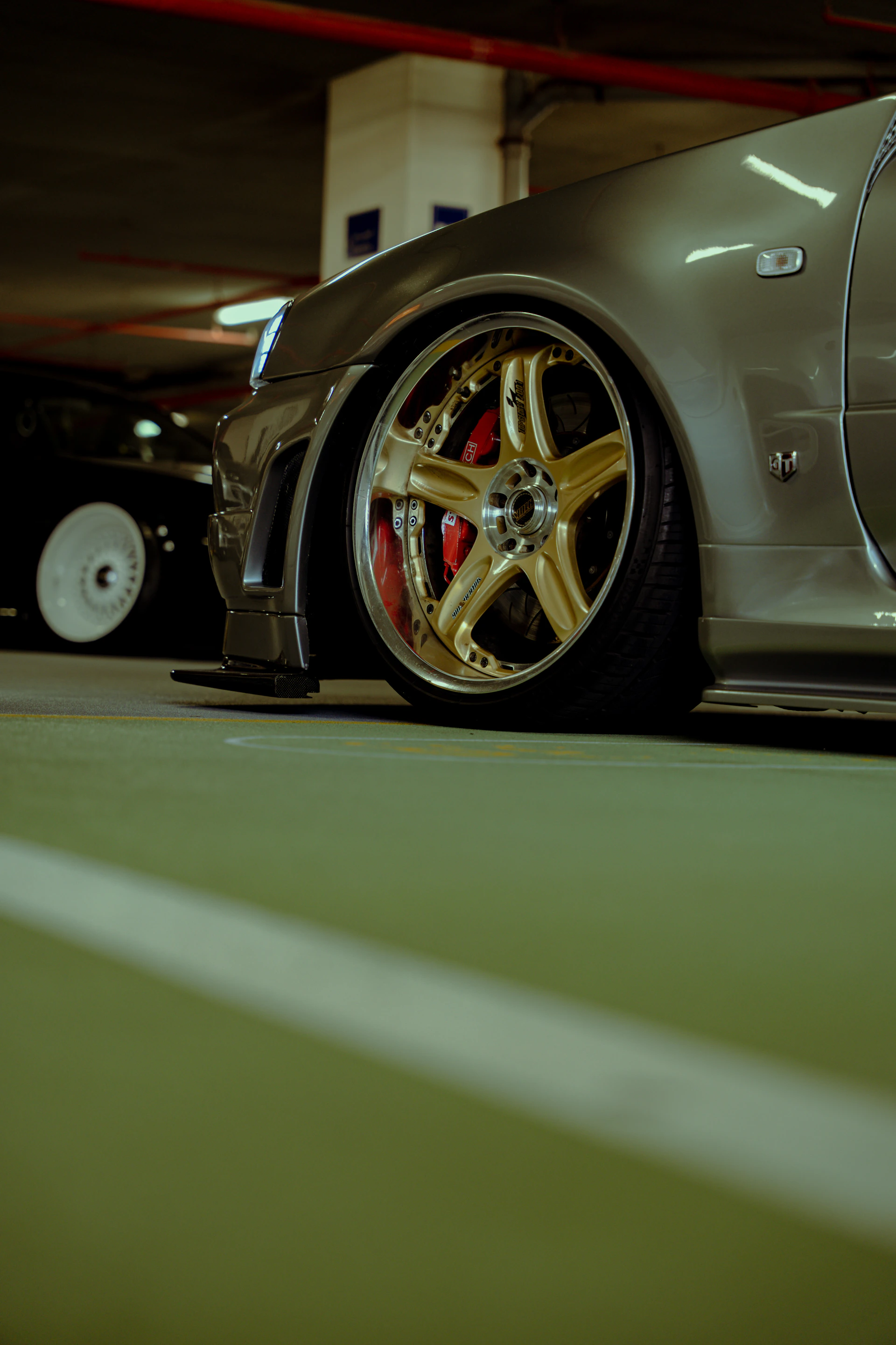 Set of polished alloy wheels and perfectly restored tires on a high-end sports car, captured at golden hour.