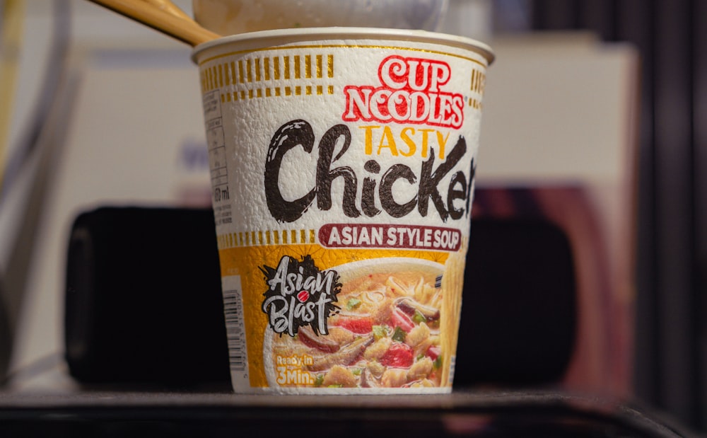 a cup of noodles with a spoon sticking out of it