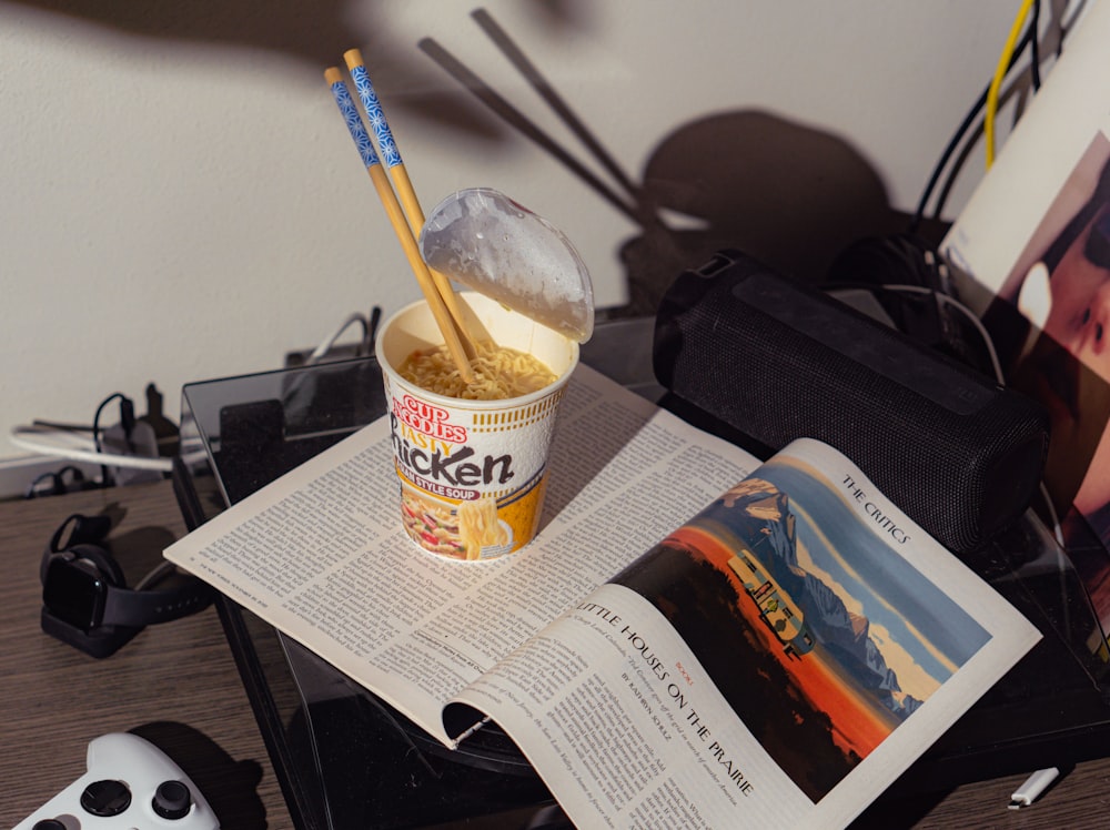a cup of ice cream and a book on a table