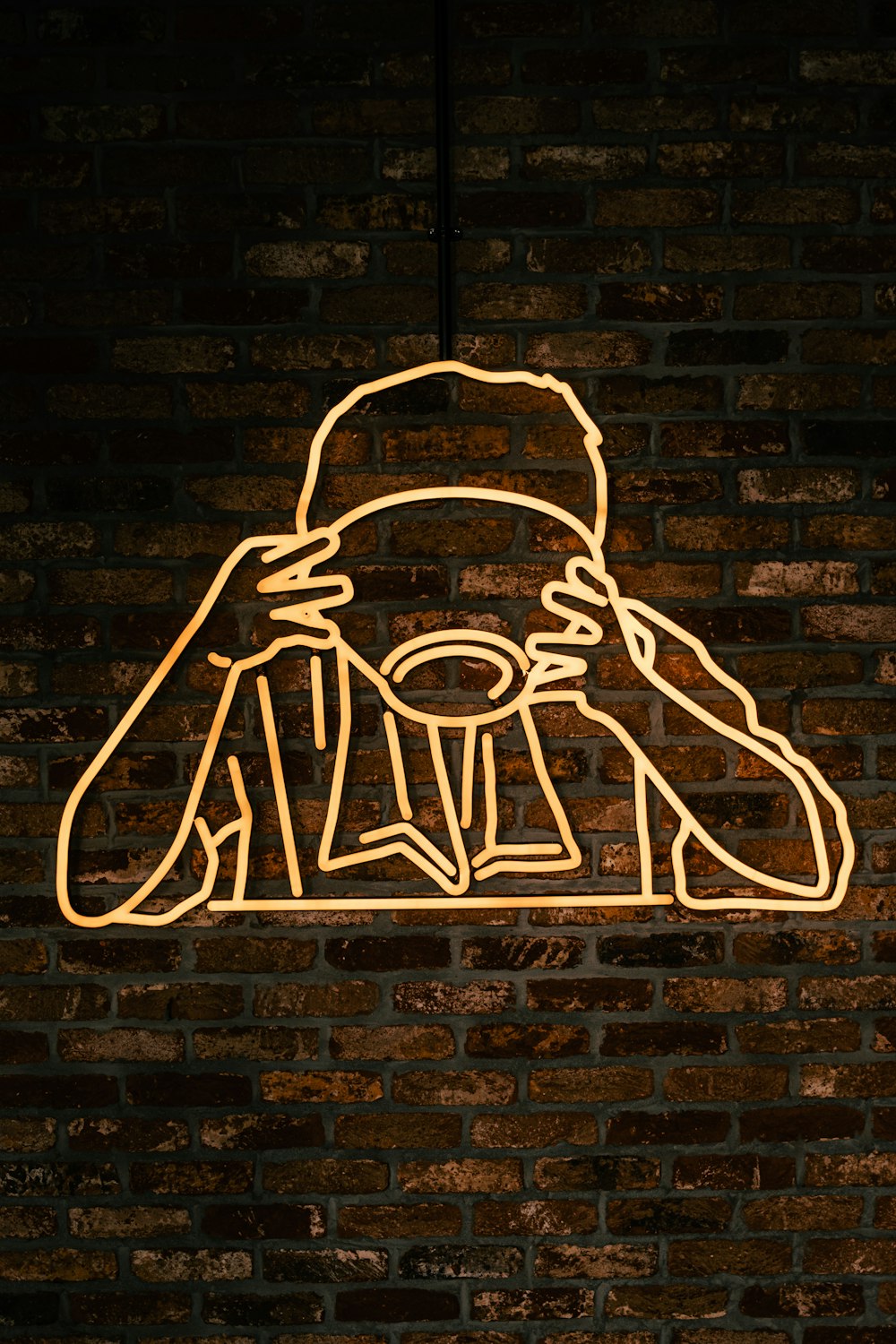 a neon sign of a person with a hat on