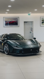 Sleek black sports car parked under moody lighting in a modern showroom.