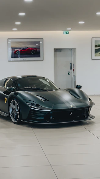 A sleek black luxury sports car parked in a minimalist showroom with soft lighting.