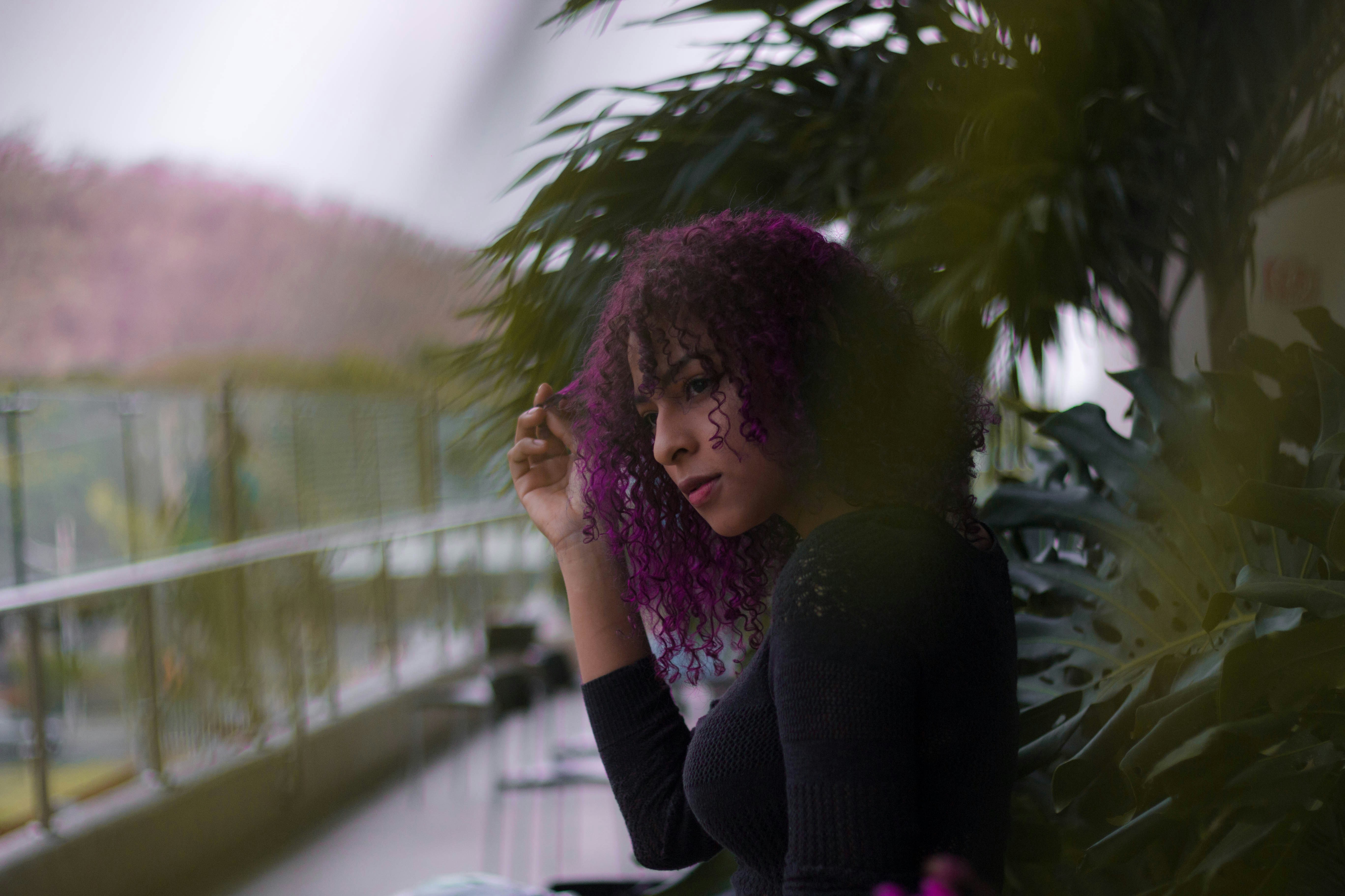 a woman with purple hair sitting on a bench
