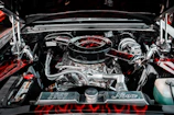 Chrome rims of the Nova shining under street lamps beside the softly glowing neon sign reading 'fire your boss now.'