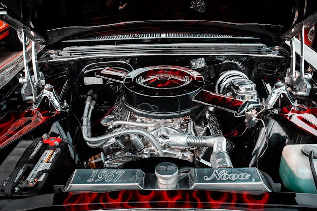Chrome rims of the Nova shining under street lamps beside the softly glowing neon sign reading 'fire your boss now.'