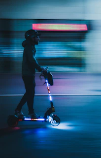 Lightning-fast axv tm-fs scooter gliding through a sleek cityscape at dusk.
