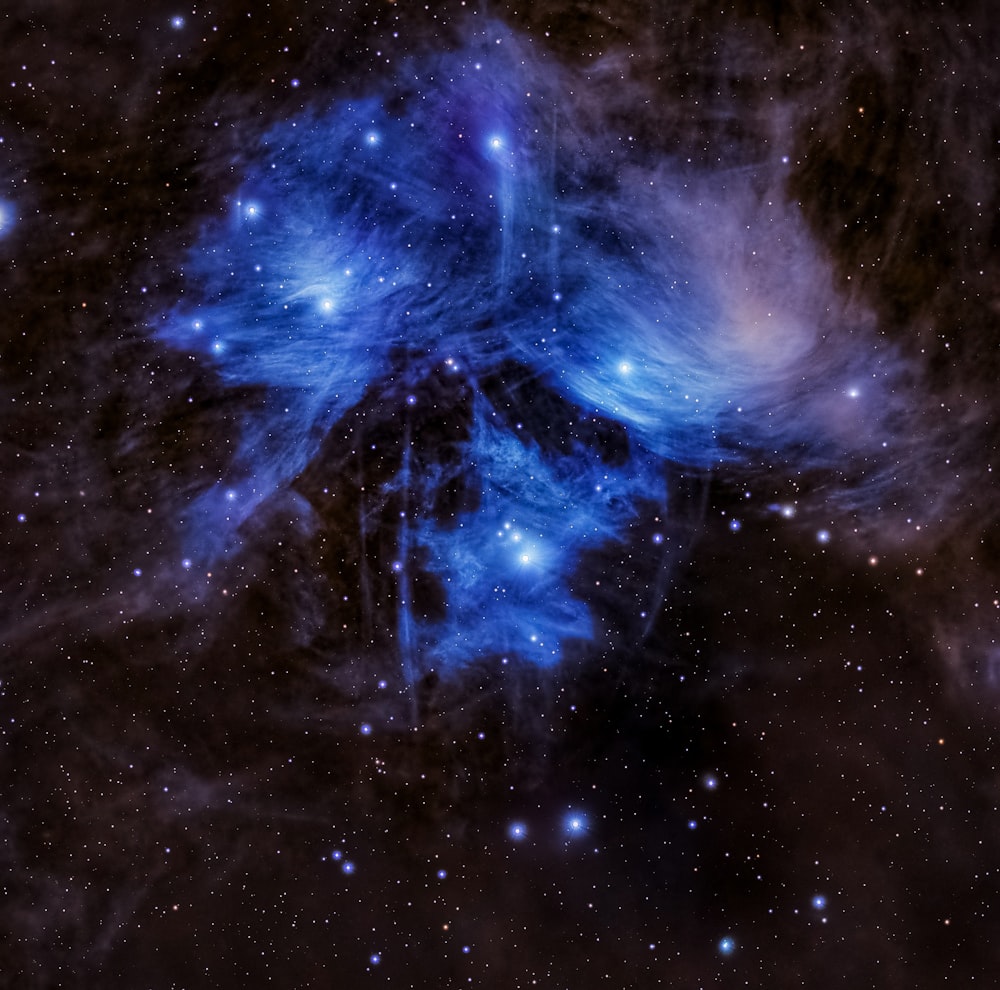 a blue star cluster in the middle of the night sky