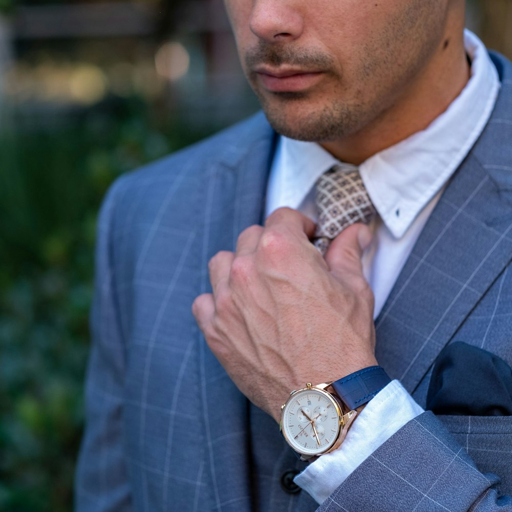 a man in a suit adjusting his tie