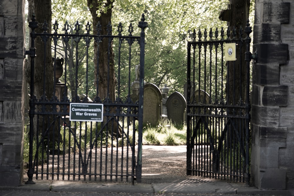 a gated entrance to a cemetery with a sign on it