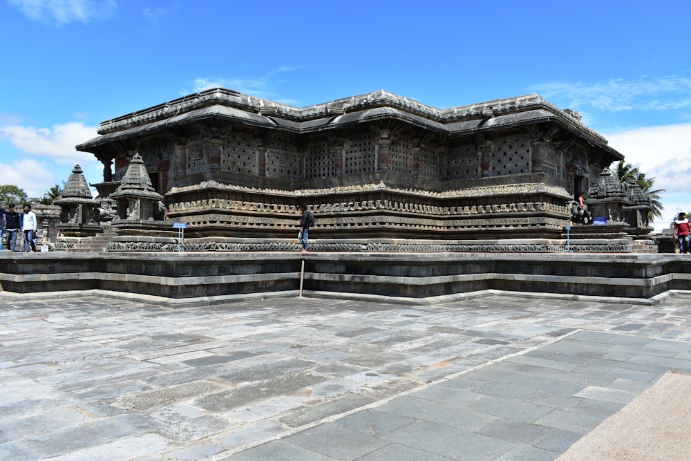 a group of people standing around a stone structure