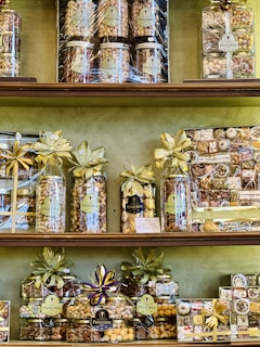 A beautifully arranged gift hamper featuring assorted nuts in glass jars and pouches.