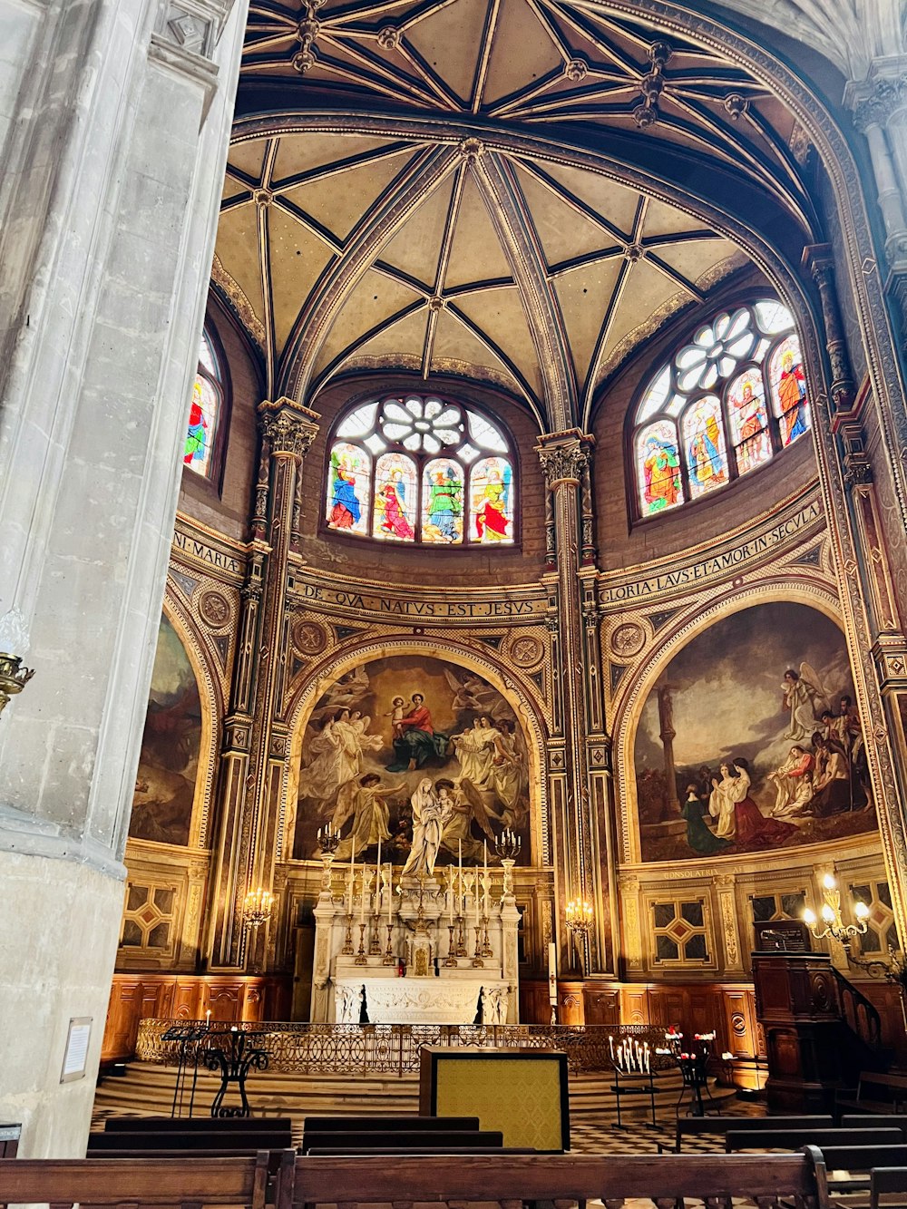 a church with a large alter and stained glass windows