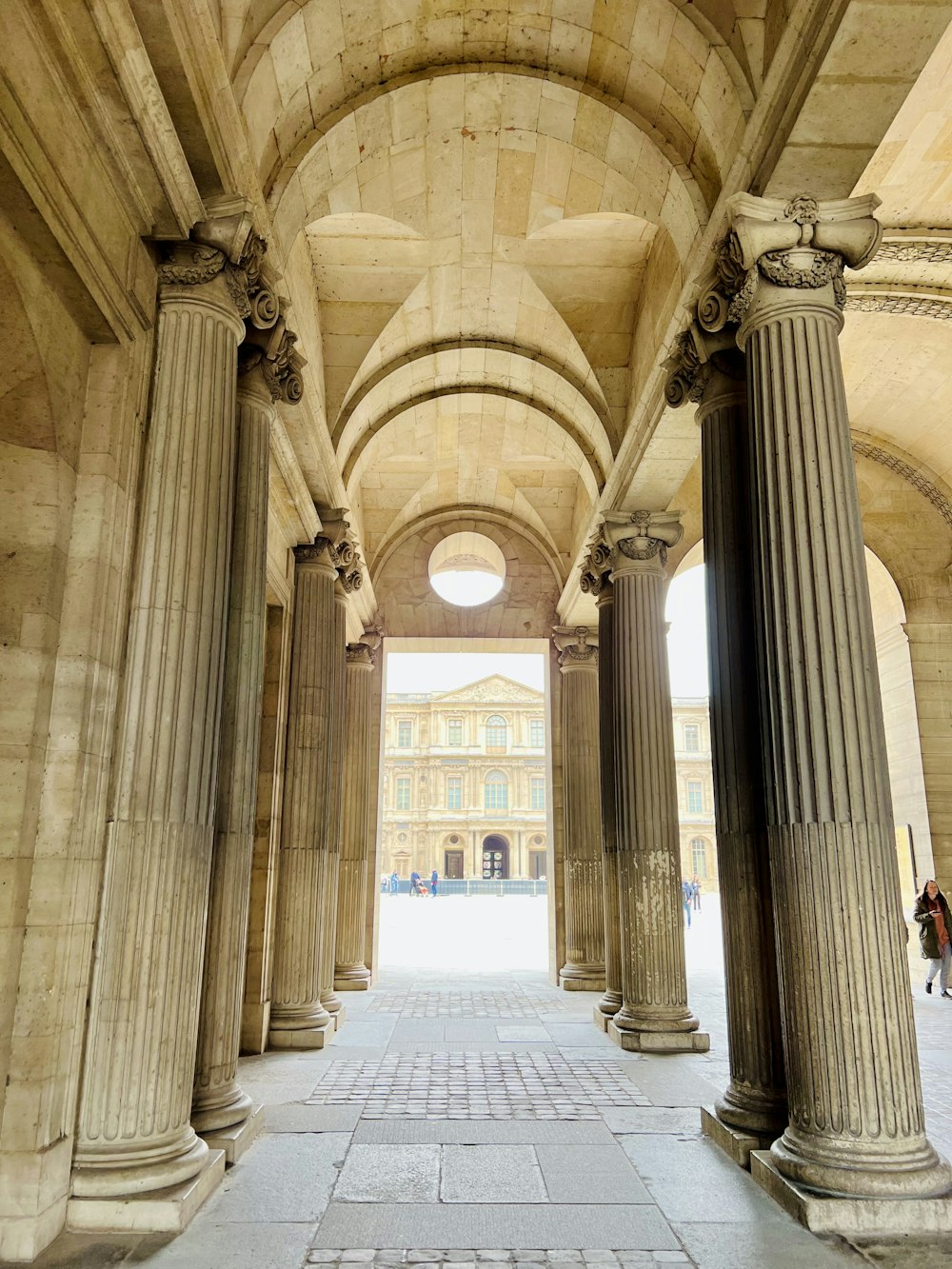 a hallway with columns and a clock on the wall