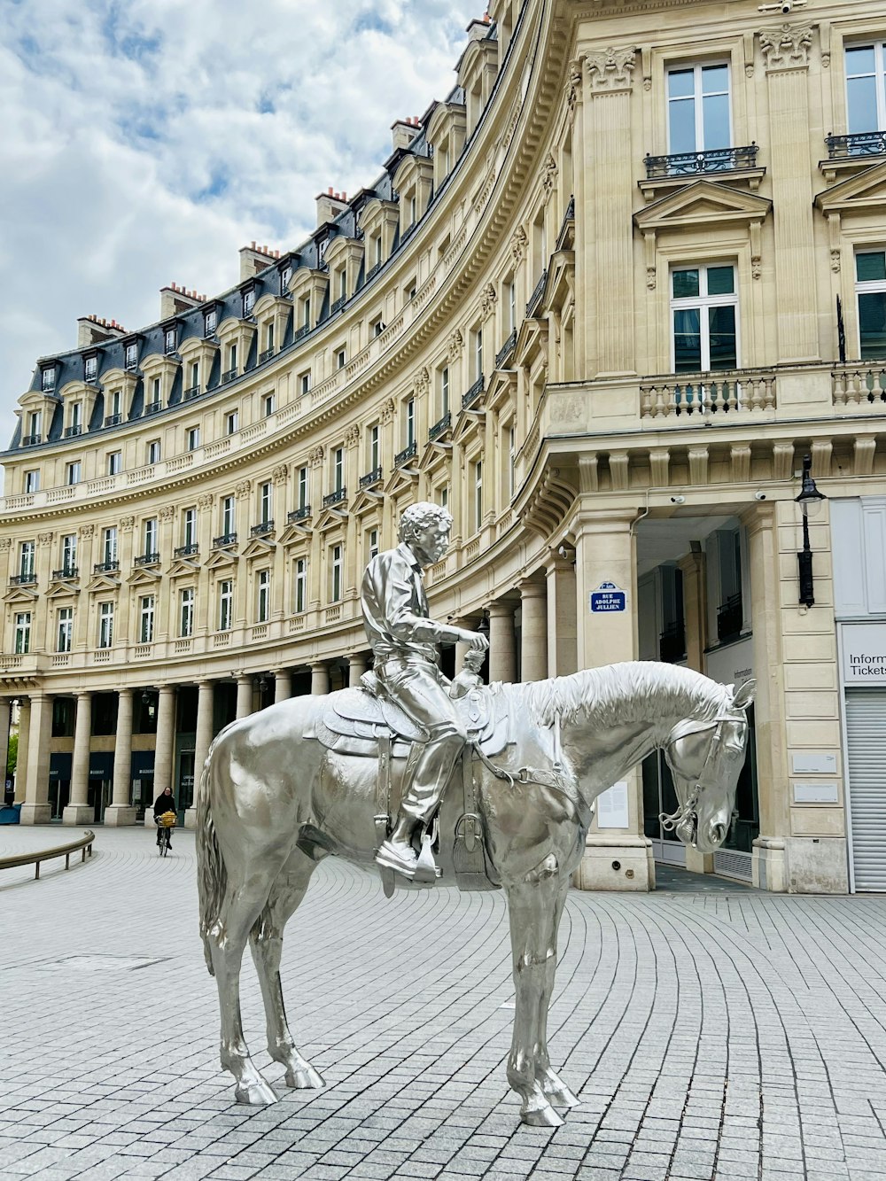 a statue of a man on a horse in front of a building