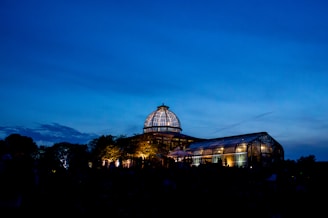 Evening shot of a conservatory with warm light glowing through windows beneath a classic-style plastic roof.