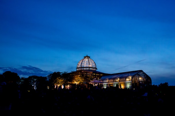 Evening shot of a conservatory with warm light glowing through windows beneath a classic-style plastic roof.