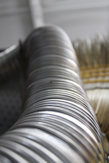Macro shot of bright coiled flat steel with smooth, reflective surface and precise curvature