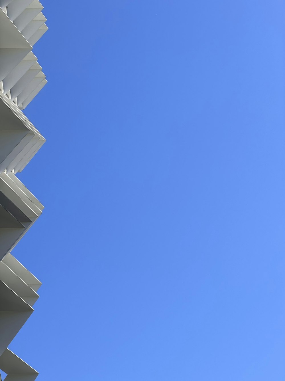 a tall white building with a blue sky in the background