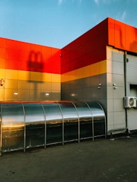 Facade of an industrial building with newly installed thermal insulation panels under bright sunlight.