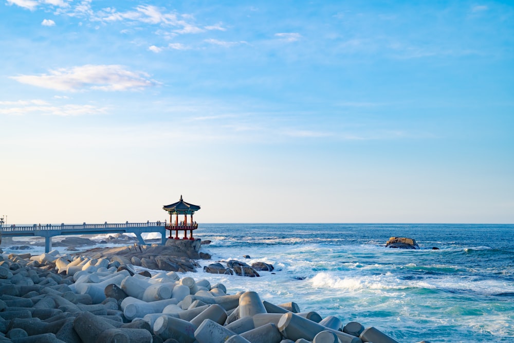 a lighthouse on a rocky shore next to the ocean